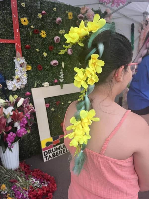 Coafură cu flori galbene împletite, realizată la un atelier