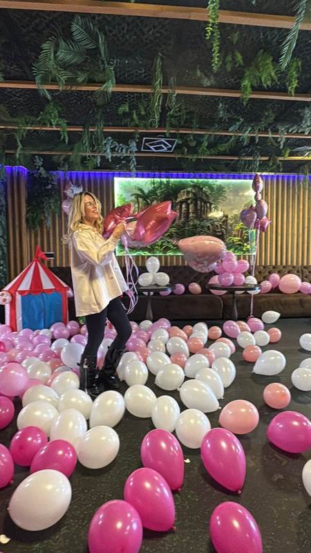 Florentina pregătind decorul cu baloane roz și albe pentru o petrecere de copii